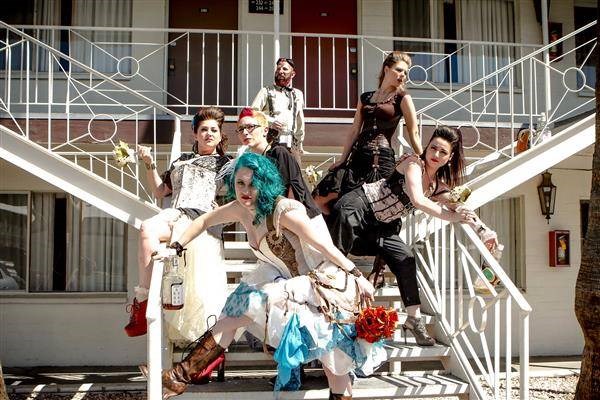 Steampunk bride, bridesmaids and guests posing outside motel