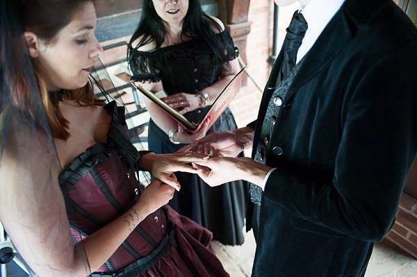 Alternative wedding celebrant and couple exchanging rings.