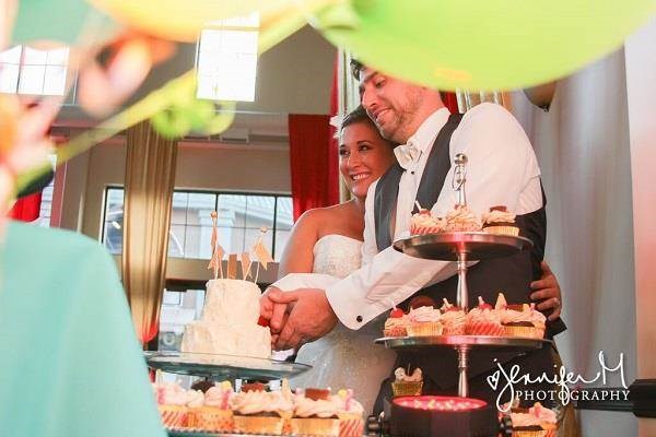 Bride & groom cutting the cake at their carnival themed wedding