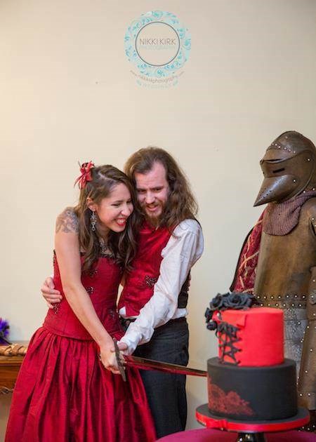 Cutting the cake with a sword at a Gothic wedding