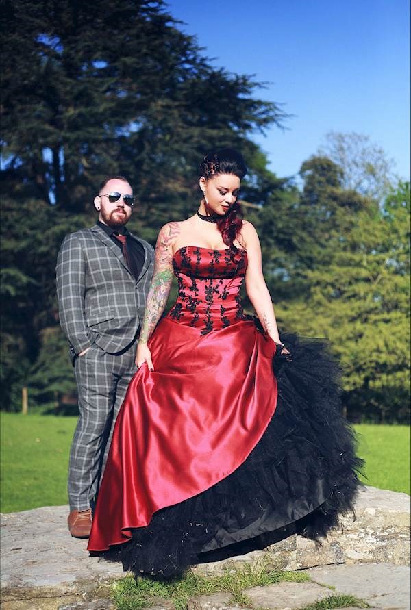 The groom wearing tartan and the bride in red and black at their alternative wedding