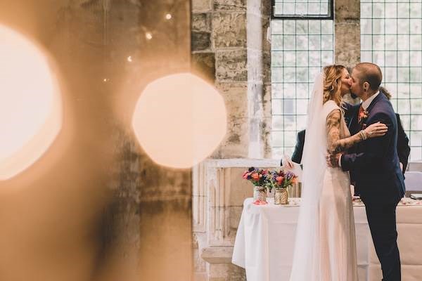 Groom kissing his bride after exchanging vows.